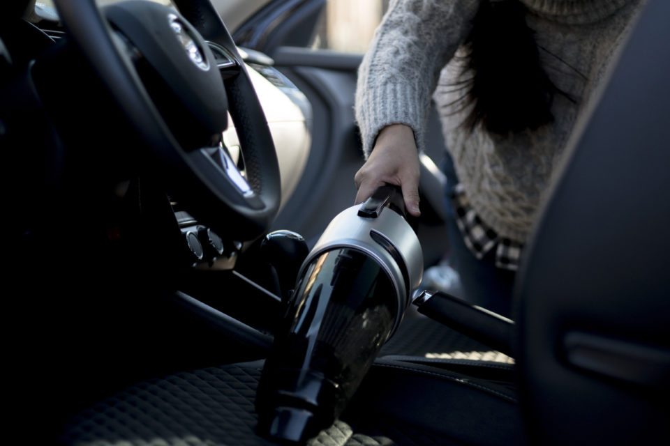 cleaning car interior with portable vacuum cleaner