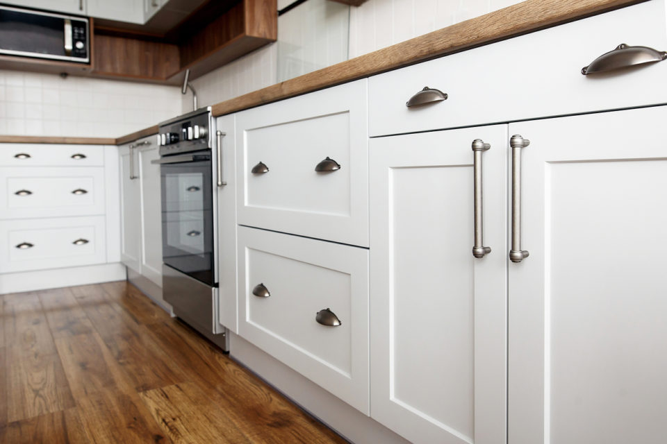 Stylish light gray handles on kitchen cabinets