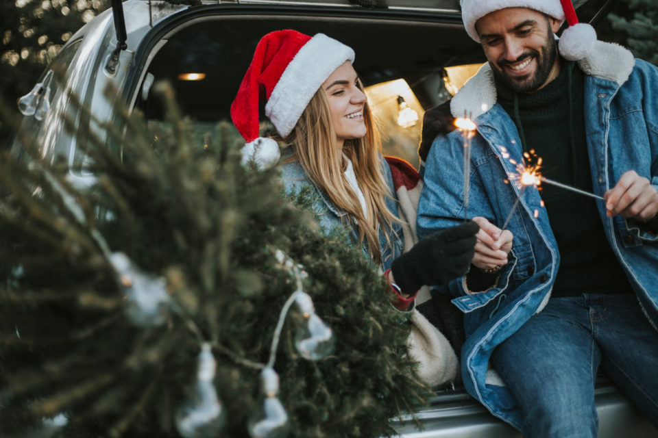 Couple having fun on Christmas tree adventure.