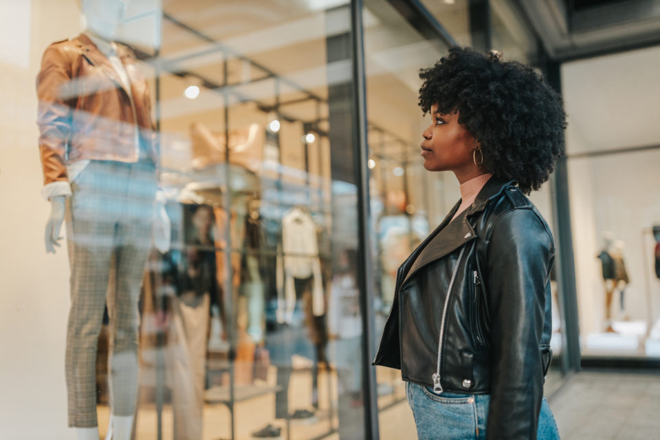 female standing in front of shop window