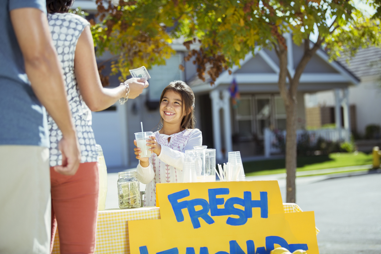 Girl selling lemonade at lemonade stand