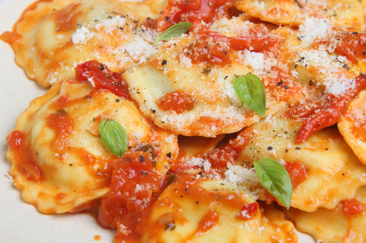 Ravioli pasta in a tomato and pepper sauce, grated Parmesan cheese and freshly ground pepper.