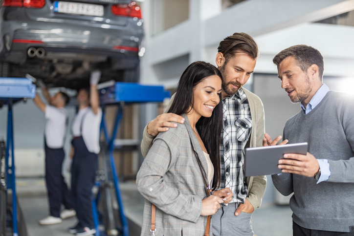 service center manager going over repairs with couple