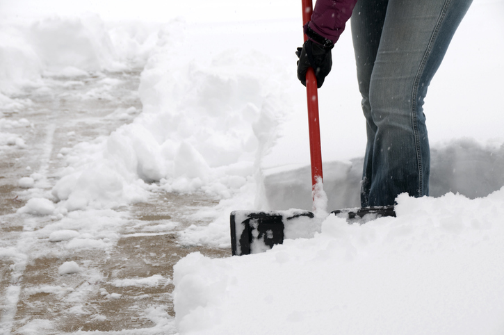 woman using plastic snow shovel to remove heavy snow from the sidewalk.See more related images in my Winter Snow Removal lightbox:
