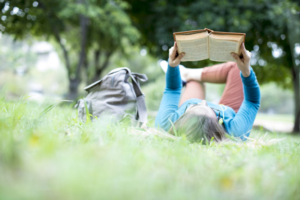 Young woman reading book at outdoor.