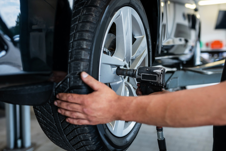 A mechanic changes a tire in a car repair shop.